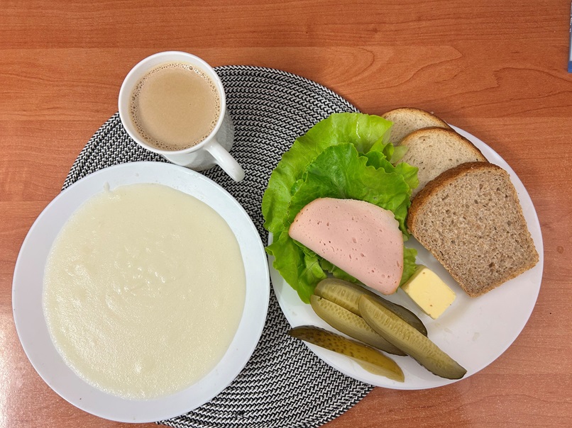 Na zdjęciu: Kasza manna na mleku, Kawa zbożowa z mlekiem, Chleb mieszany pszenno-żytni, Chleb Graham, Masło extra 82%, Filet zapiekany drobiowy, Ogórek kiszony, Sałata zielona